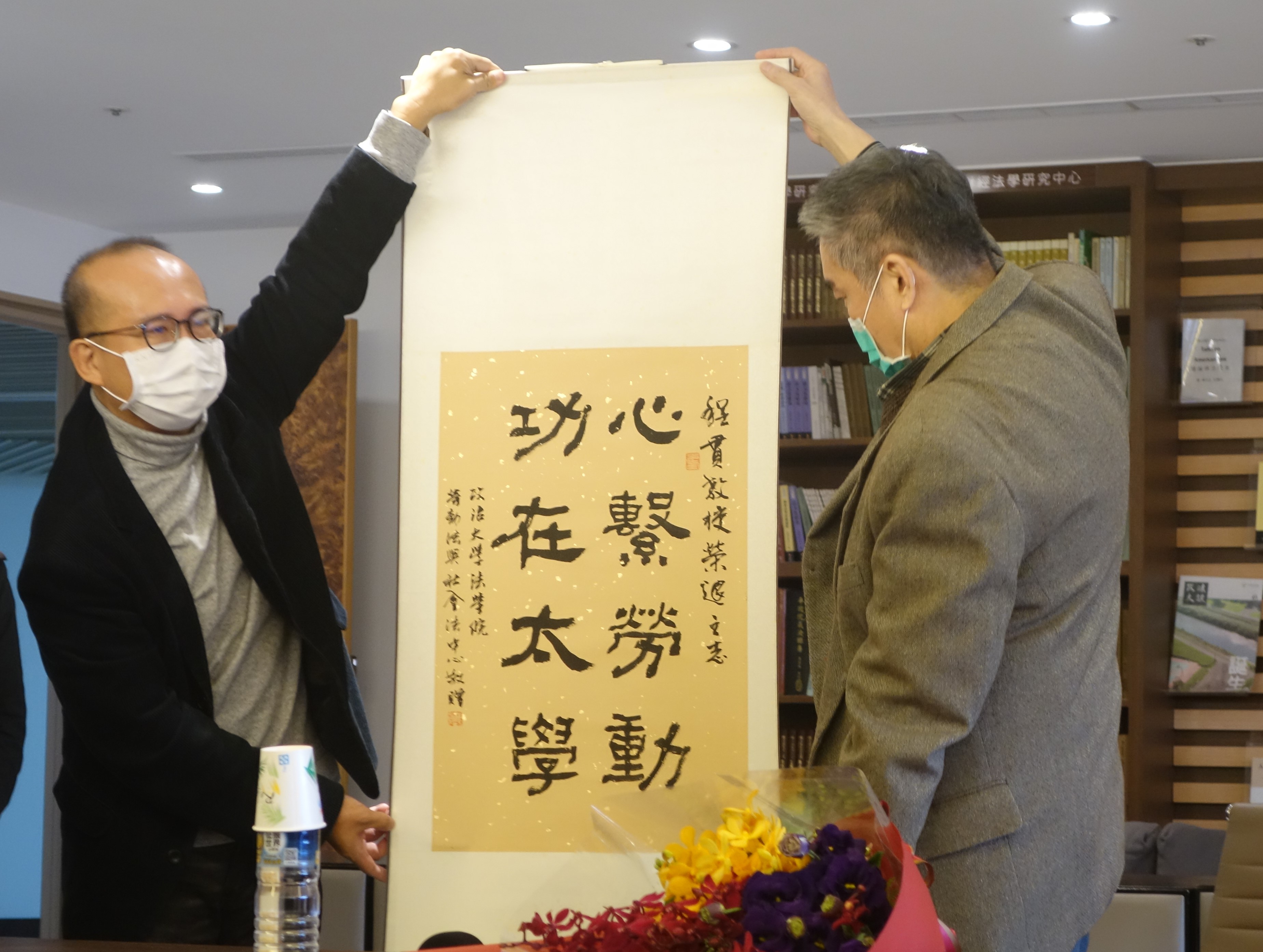 圖二：勞動法與社會法中心林良榮主任（左）代表中心致贈墨寶