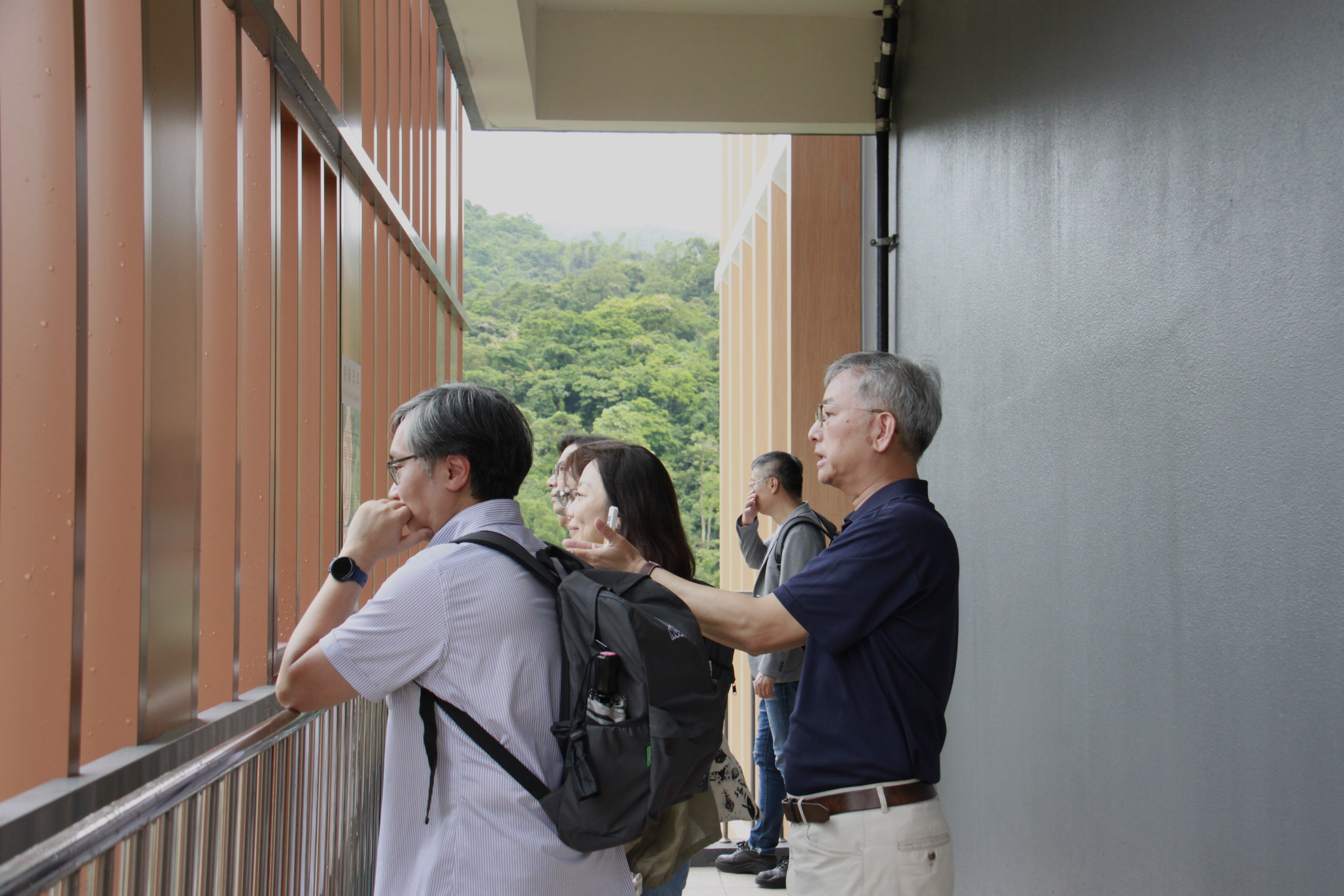 法學院一側的陽台可以欣賞指南山區的全貌，圖為王文杰教授(右一)為校友說明。