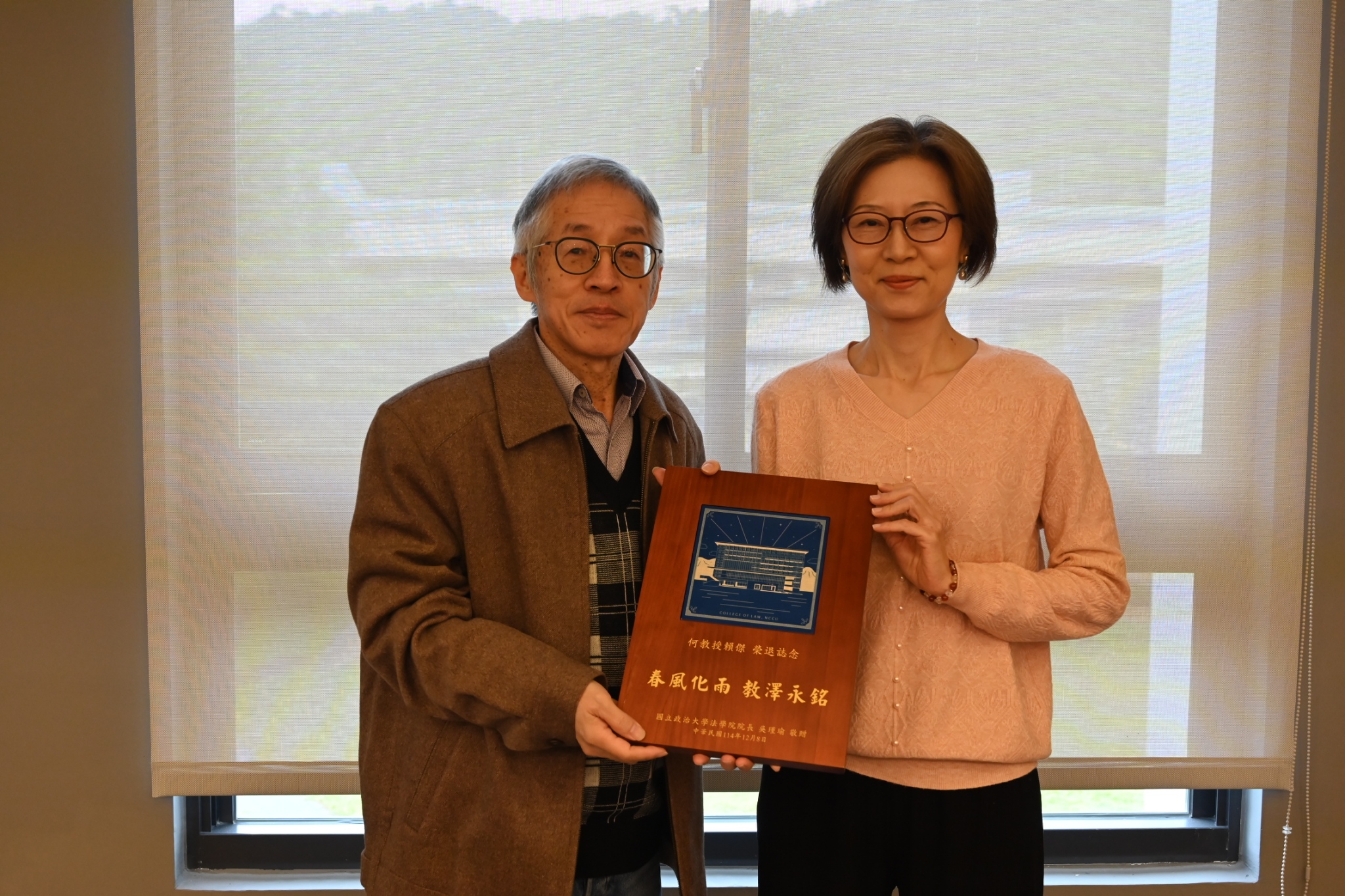 吳瑾瑜院長（右）頒贈磚燒與何賴傑教授（左）。