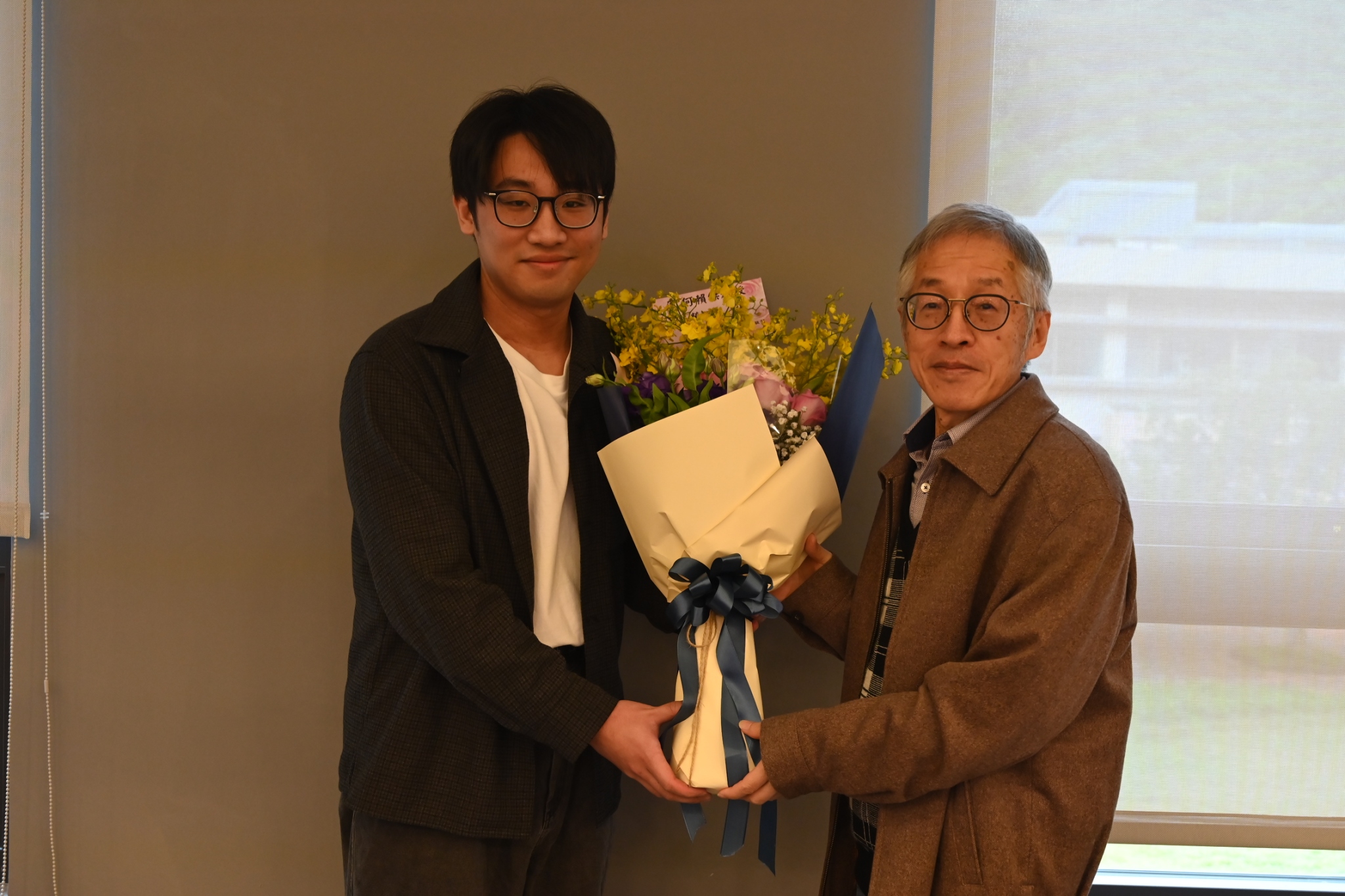 指導學生代表獻花與何賴傑教授（左）。